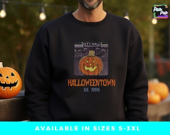 Peut inclure: Sweat-shirt noir avec un graphique d'une citrouille sculptée devant un bâtiment qui dit "City Hall". Le texte sous le graphique dit "Halloweentown Est. 1998".