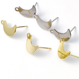 May include: A set of six earring findings with crescent moon shapes. Three are gold-toned and three are silver-toned. Each finding has a post and a loop.