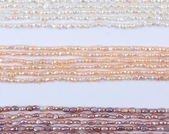 May include: Several strands of freshwater pearls in different colours. The top strands are white, the middle strands are peach, and the bottom strands are pink and purple. The pearls are irregularly shaped and strung together, ideal for jewellery making.