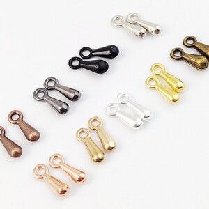 Puede incluir: Surtido de 10 pares de hallazgos de joyería de metal en forma de lágrima en varios acabados, incluyendo oro, plata, bronce y negro.