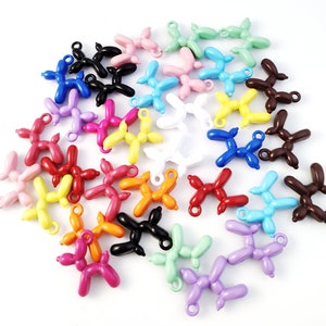 May include: A collection of colorful balloon dog charms in various colors, including red, orange, yellow, green, blue, purple, pink, brown, black, and white. The charms are made of metal and have a loop at the top for attaching to a necklace, bracelet, or keychain.