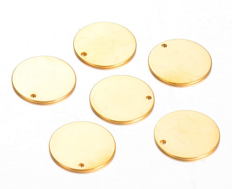 Pu&ograve; includere: Sei cerchi di metallo color oro con un piccolo foro al centro. I cerchi sono lisci e lucidi.