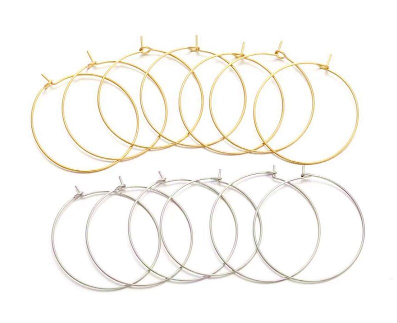 May include: A set of 10 hoop earrings, 5 gold and 5 silver. The hoops are all the same size and are made of a thin wire.