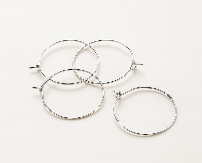 May include: Three silver hoop earrings, each with a simple circular design.