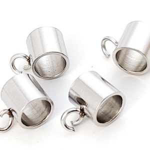 May include: Four silver-toned metal bead caps with a loop on the side. The bead caps are cylindrical and have a smooth, polished finish.