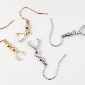 Op de afbeelding: Vier oorhaken, twee goud en twee zilver, met veerbelaste sluitingen. De haken zijn ontworpen om sieradenbevestigingen aan te bevestigen.