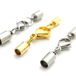 May include: Three silver and gold metal end caps for jewelry making. The end caps have a small loop on one end and a cylindrical cap on the other end. The caps are used to finish off the ends of necklaces, bracelets, and other jewelry.