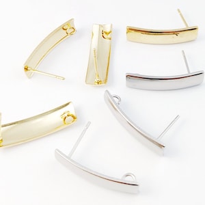 May include: Five earring blanks, two gold and three silver, with a curved shape and a post for attaching earrings. The blanks are designed for adding charms or other embellishments.