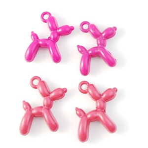 May include: Four balloon animal charms in pink and red. The charms are shaped like dogs and have a loop at the top for attaching to a necklace or bracelet.