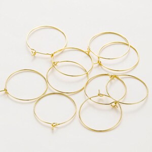 May include: A set of eight gold-toned hoop earrings. The hoops are of varying sizes and are arranged in a cluster.