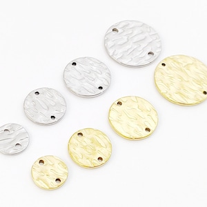May include: Assortment of round metal charms with a textured surface and two holes. The charms are in silver and gold.