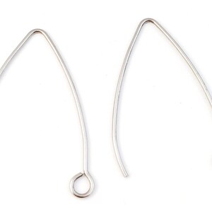 May include: Two silver earring hooks with a small loop at the end. The hooks are made of metal and are designed to be used with earrings.