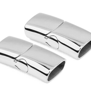 May include: Two silver magnetic clasps for jewelry making. The clasps are made of metal and have a smooth, polished finish.