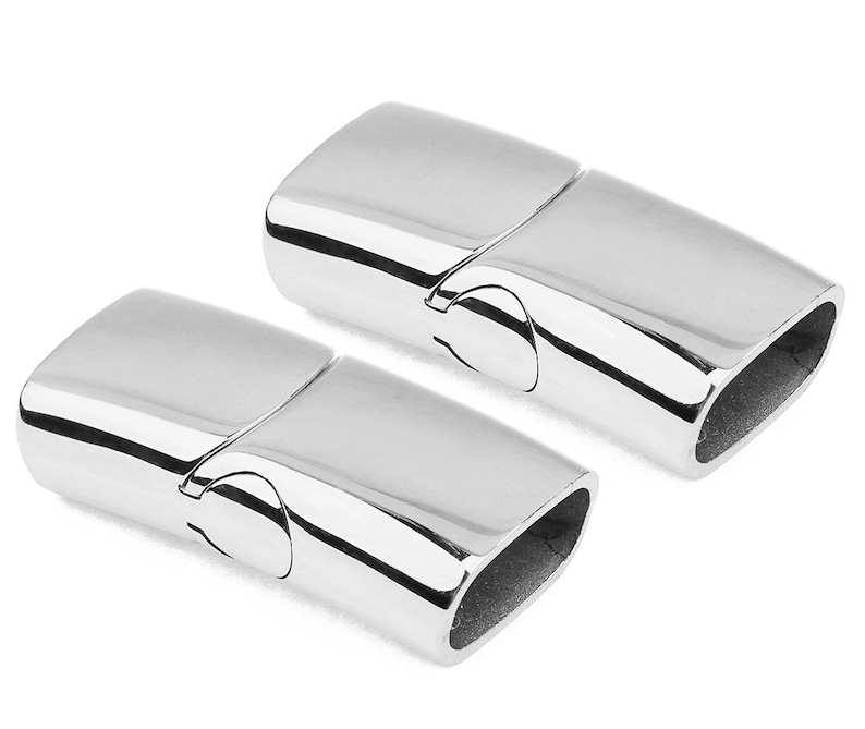 May include: Two silver magnetic clasps for jewelry making. The clasps are made of metal and have a smooth, polished finish.