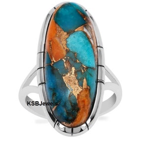 May include: A silver ring featuring a large oval turquoise and copper inlay stone. The stone displays a blend of blue, green, and orange hues.