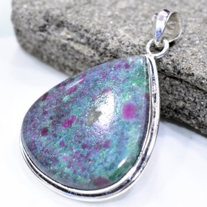 May include: A teardrop-shaped pendant featuring a green and pink ruby zoisite gemstone set in sterling silver.