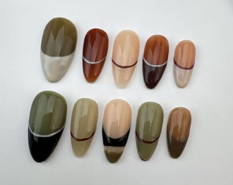 May include: Set of ten false nails with a green, brown, and beige color scheme. Each nail has a thin white or black line across the middle.