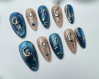 May include: Set of ten blue and gold nail tips with crescent moon and star designs.
