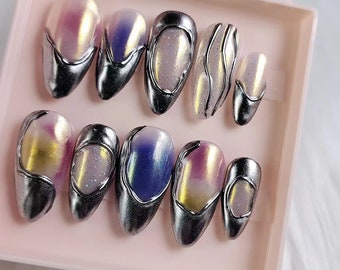 May include: A set of ten iridescent press-on nails with silver tips. The nails have a variety of colors and patterns, including pink, blue, and purple.