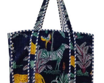 May include: A navy blue tote bag with a white and blue trim. The bag features a colorful print of zebras, leopards, and tropical plants.