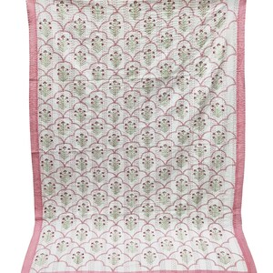 May include: A pink and white kantha quilt with a floral pattern. The quilt has a pink border and is made of cotton.