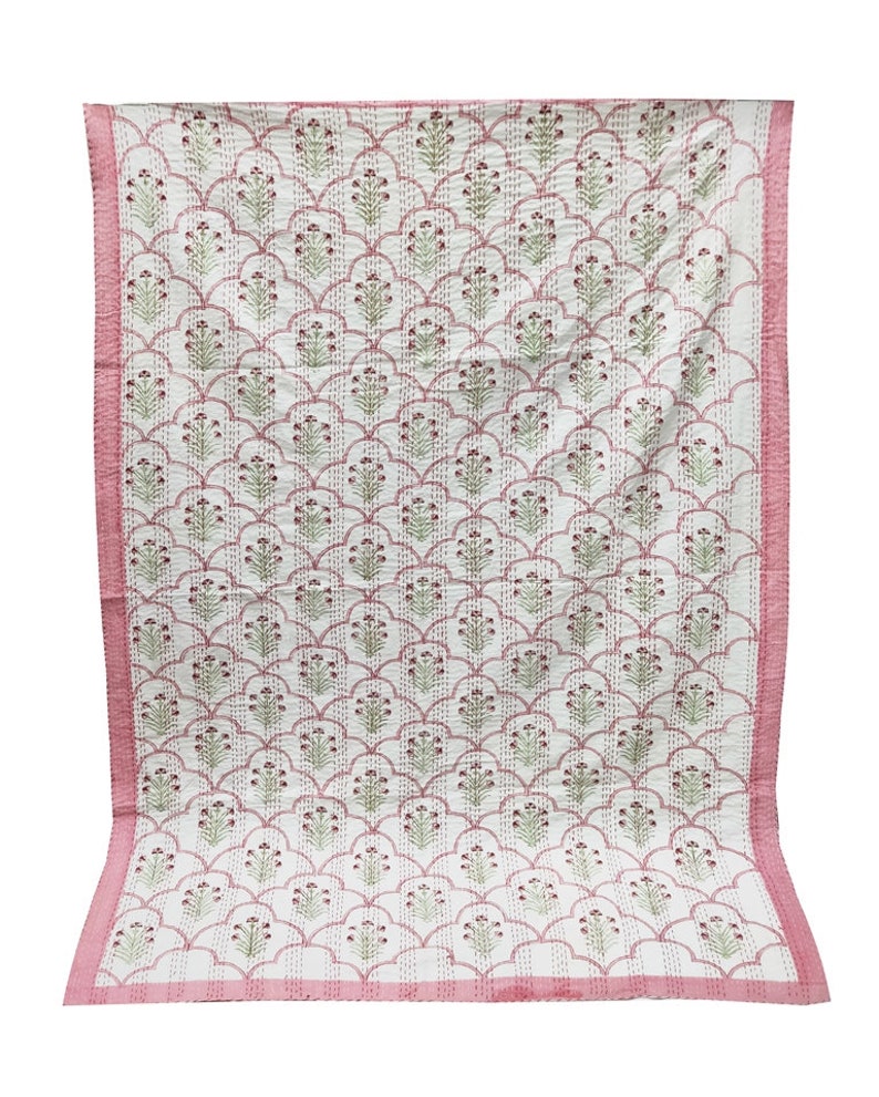 May include: A pink and white kantha quilt with a floral pattern. The quilt has a pink border and is made of cotton.