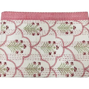 May include: A white cotton quilt with a pink floral pattern. The quilt is hand-stitched with a running stitch and has a pink border.