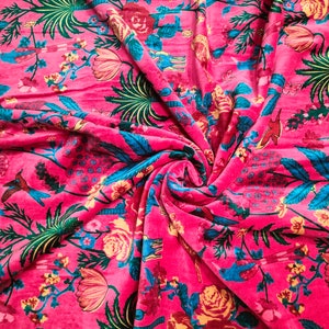 May include: Pink fabric with a floral print featuring blue birds, green leaves, and yellow flowers.