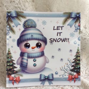 May include: A square card featuring a cartoon snowman wearing a blue and white striped hat and scarf. The snowman has a carrot nose and two blue gem buttons. The text "LET IT SNOW!!" is displayed. The card is decorated with bows and snowflakes.