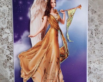 May include: A Christmas card featuring an angel with golden wings and a golden dress, holding a trumpet. The background is a purple and blue gradient with stars. The card reads "Merry Christmas".