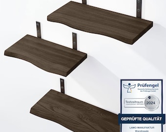 May include: Three dark brown wooden wall shelves with live edges and black metal mounting brackets. Each shelf features a natural wood grain pattern and is attached to the wall with vertical hardware. A certification seal is visible in the corner.