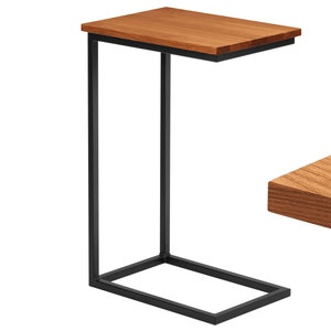 Peut inclure: Une table d'appoint en métal noir avec un plateau rectangulaire en bois. La table a un design simple et moderne.