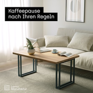 May include: A rectangular wooden coffee table with dark gray metal legs. A laptop, plant, and coffee cup sit on the table. The text "Kaffeepause nach Ihren Regeln" is in a black rectangle.