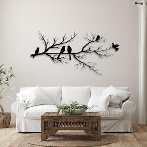 May include: A black metal wall art piece depicting a tree branch with several birds perched on it. The birds and branches are in a silhouette style, creating a minimalist and elegant design. This decorative piece is suitable for any room.