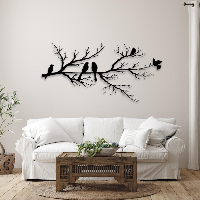 May include: A black metal wall art piece depicting a tree branch with several birds perched on it. The birds and branches are in a silhouette style, creating a minimalist and elegant design. This decorative piece is suitable for any room.
