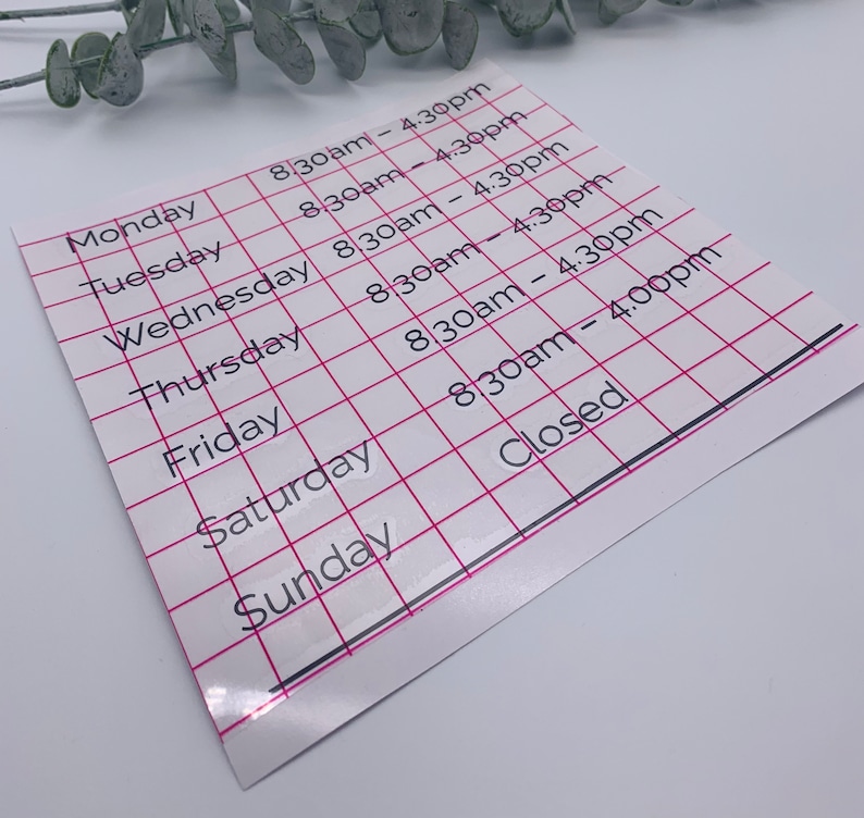 May include: A white sheet of paper with a grid pattern and black text listing business hours. The hours are listed for each day of the week, Monday through Sunday. The hours are 8:30am to 4:30pm, except for Sunday, which is closed.