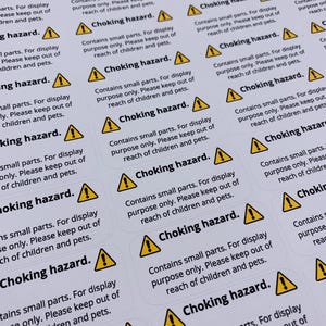 May include: A sheet of yellow and black warning labels that read "Choking hazard. Contains small parts. For display purpose only. Please keep out of reach of children and pets."