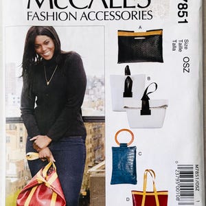 May include: McCall's M7851 fashion accessories sewing pattern envelope featuring illustrations of four bag styles: a black clutch, a white tote, a blue crocodile-textured pouch with a round handle, and a red tote with yellow straps, plus a model photo.