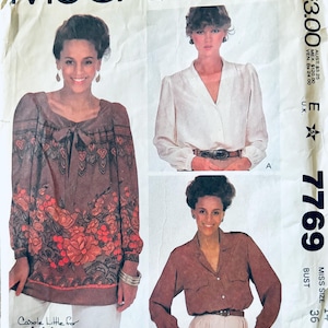 May include: Vintage McCall's sewing pattern for a blouse, featuring three different styles. The pattern is for size 36 bust and includes instructions for making a brown floral blouse, a white blouse with a V-neck, and a brown blouse with a collar.