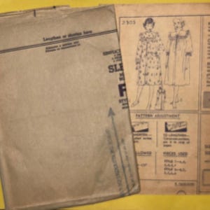 Puede incluir: Patr&oacute;n de costura vintage con un sobre de papel marr&oacute;n y una hoja de patr&oacute;n impresa. El sobre tiene texto en la parte superior y una flecha azul. La hoja de patr&oacute;n presenta ilustraciones de dos mujeres con abrigos.