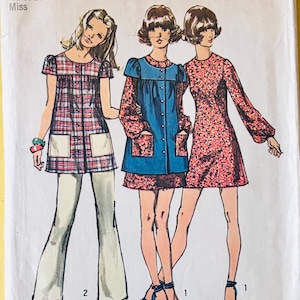 Puede incluir: Patrón de costura Simplicity 9834 vintage con tres diseños de moda femenina. La ilustración incluye una túnica a cuadros con pantalones blancos, un vestido túnica azul y un vestido con estampado floral. El patrón es talla 10, con un busto de 82,5 cm y una cintura de 61 cm.
