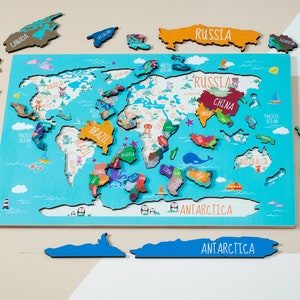 Wooden world map Montessori puzzle for kids features a colorful world map with the names of the countries, continents, and oceans.