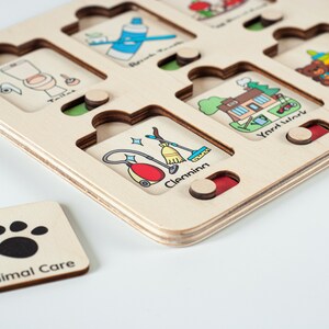 May include: Wooden puzzle board with various chores illustrated on each piece. The pieces are labeled with the chore name, such as "Toilet", "Brush Teeth", "Yard Work", and "Play Time". A separate piece with a paw print is labeled "Animal Care".