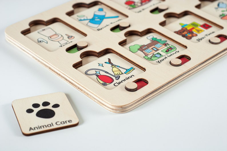 May include: Wooden puzzle board with various chores illustrated on each piece. The pieces are labeled with the chore name, such as "Toilet", "Brush Teeth", "Yard Work", and "Play Time". A separate piece with a paw print is labeled "Animal Care".