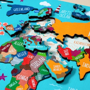 Wooden world map Montessori puzzle for kids features a colorful world map with the names of the countries, continents, and oceans.