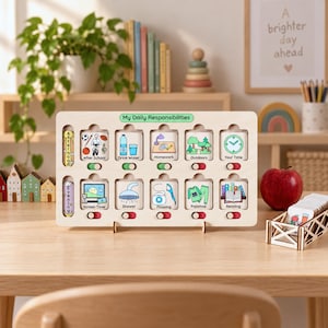 Puede incluir: Un tablero de responsabilidades diarias de madera clara con diez ranuras cuadradas que incluyen iconos ilustrados y etiquetas de texto para tareas como deberes, ducha y lectura, cada una con un peque&ntilde;o interruptor deslizante debajo.