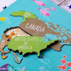 Wooden world map Montessori puzzle for kids features a colorful world map with the names of the countries, continents, and oceans.