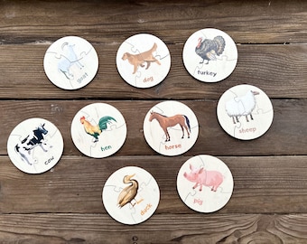 May include: A set of nine circular wooden puzzle pieces, each featuring a colorful illustration of a farm animal including a goat, dog, turkey, cow, hen, horse, sheep, duck, and pig, with the corresponding animal name printed in lowercase text.