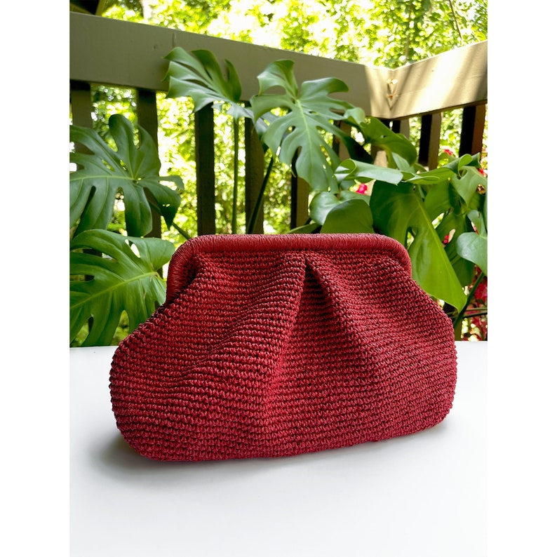 Puede incluir: Un bolso de mano de crochet rojo con un dise&ntilde;o fruncido.