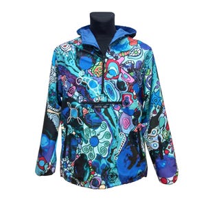 May include: A vibrant, abstract patterned anorak jacket. The jacket features a blue hood and a colorful design with swirls, shapes, and the text "LEMINX". The anorak has a half-zip closure and a front pocket.